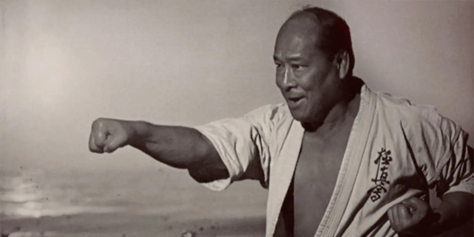 Mas Oyama in a white gi marked with the Kyokushin kanji, arm extended in a straight punch.