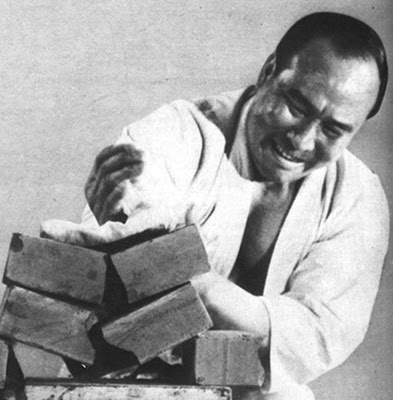 Mas Oyama striking down through a stack of bricks with the edge of his hand.